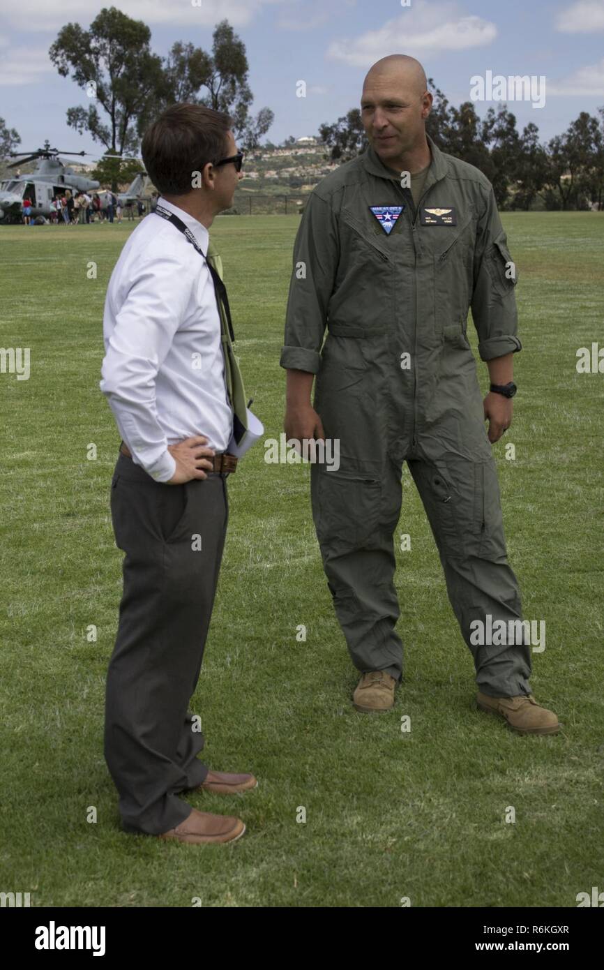 U.S Marine Sergeant Major Melvin Miller, sergeant major, Marine Light Helicopter Attack Squadron 775 speaks with one of the staff members at Calavera Hills Middle School. HMLA-775 visited Calavera Hills Middle School to inform and educate students and faculty of Marine Corps aviation assets and capabilities. Stock Photo