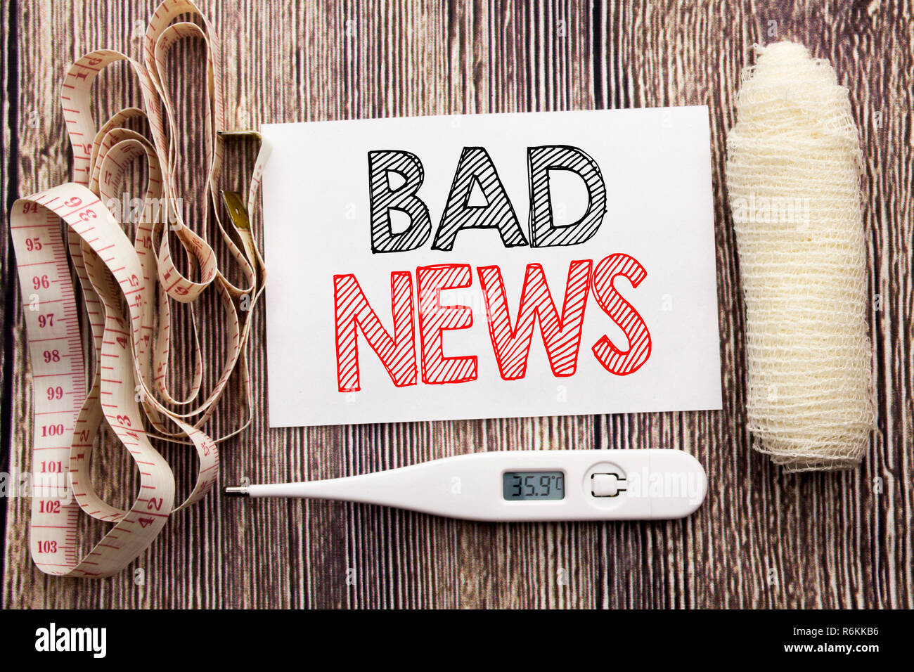 Handwritten text showing Bad News. Business fitness health concept writing for Failure Media Newspaper written sticky note empty paper background with bandage and thermometer Stock Photo