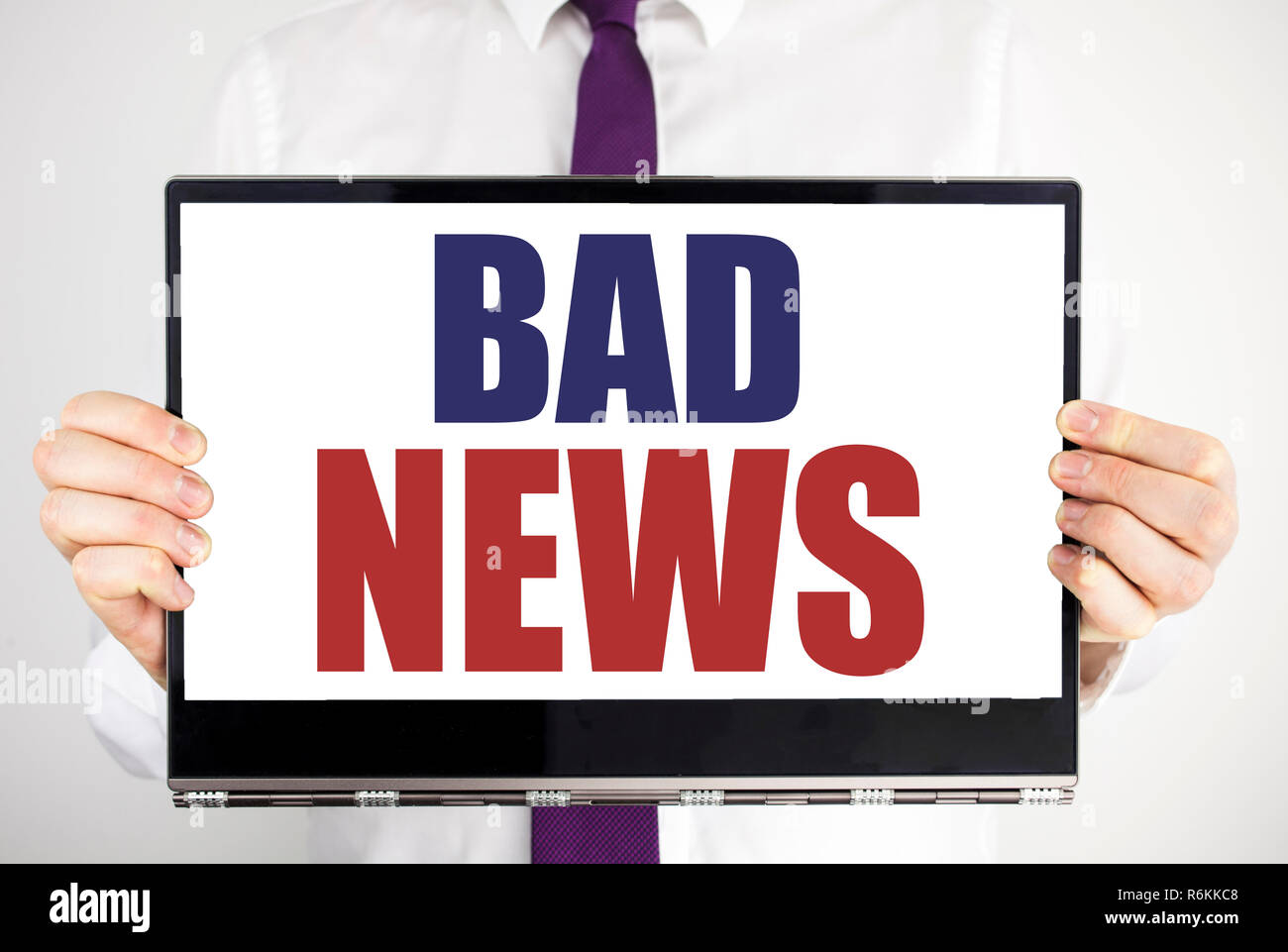 Word, writing Bad News. Business concept for Failure Media Newspaper Written on tablet laptop holding by the man blurred background. Businessman fingers keeping the computer. Stock Photo