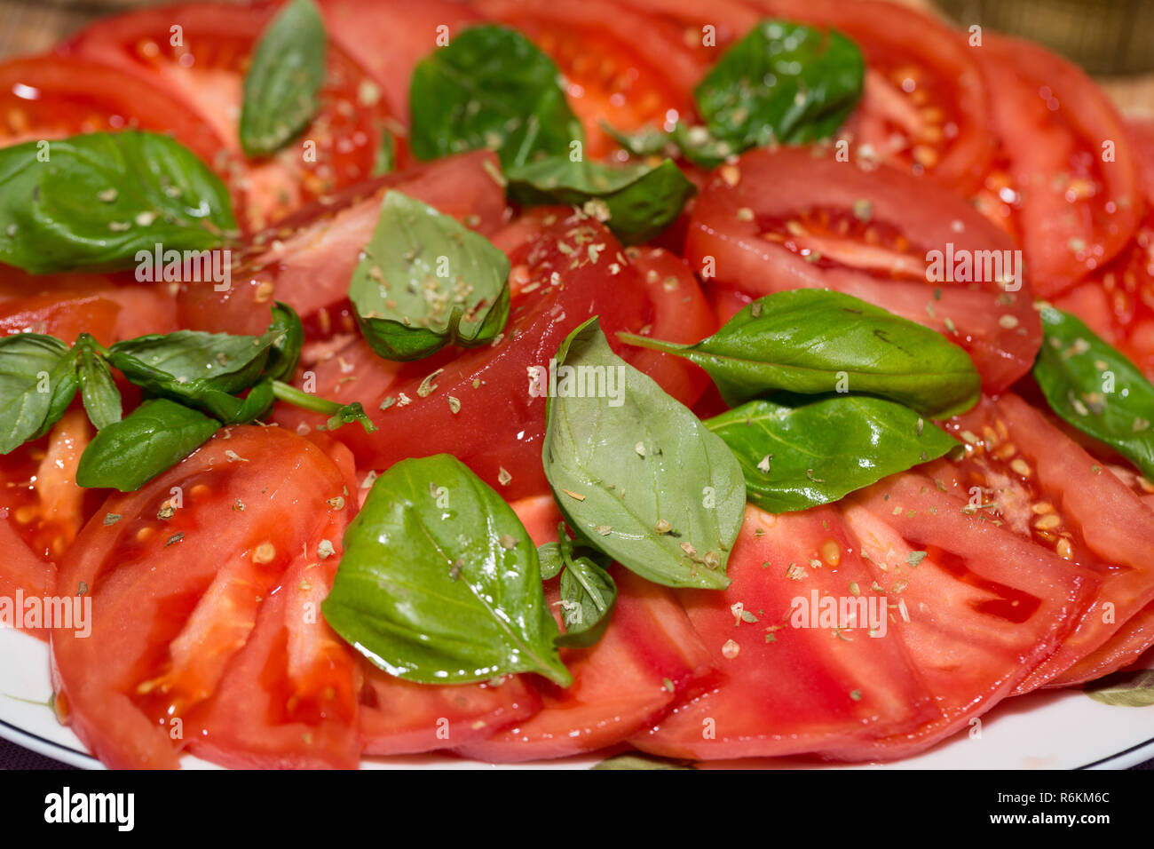 sliced of tomatoes with basil Stock Photo - Alamy