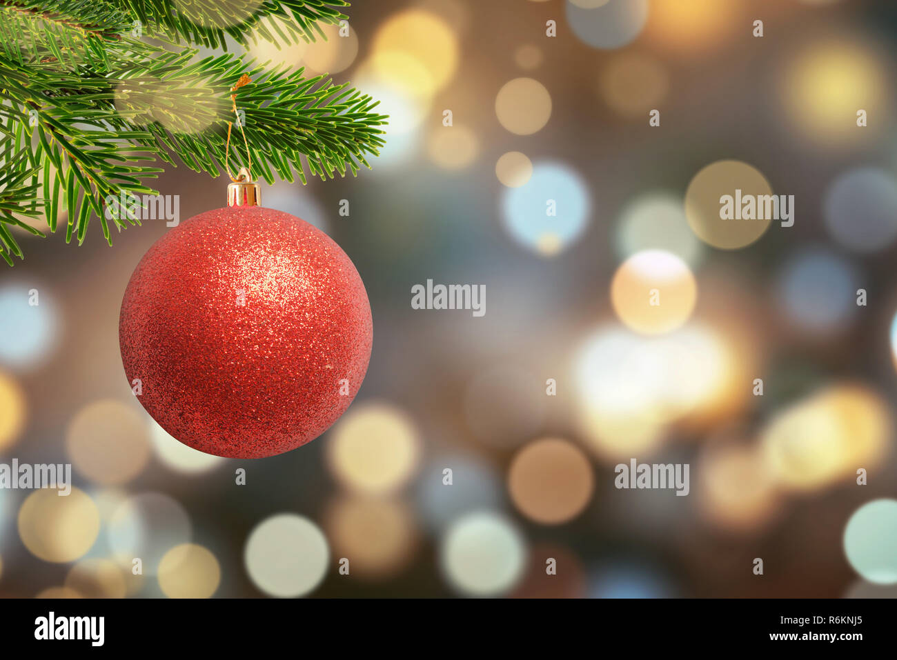 Christmas shiny ball on tree and Christmas lights, bokeh in background. Free space for Greeting text. Stock Photo