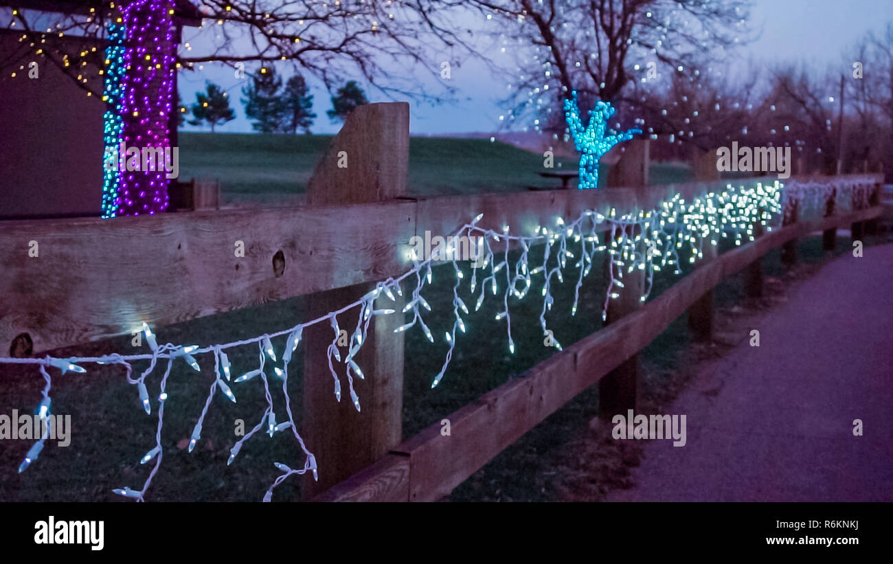 Outdoor Christmas lights on the fence in the park. Stock Photo