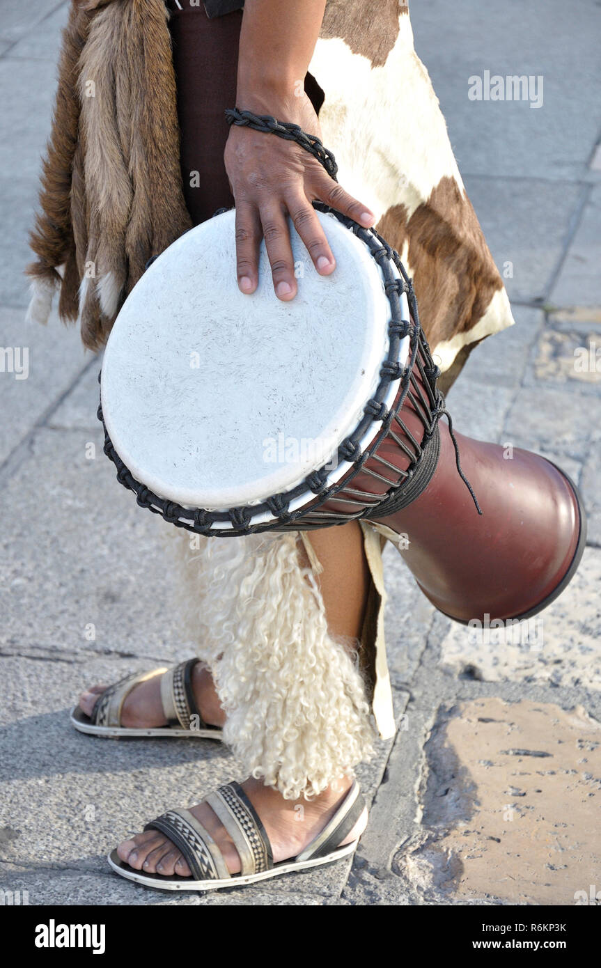 Man wearing a folk costume of South Africa with a african djembe drum