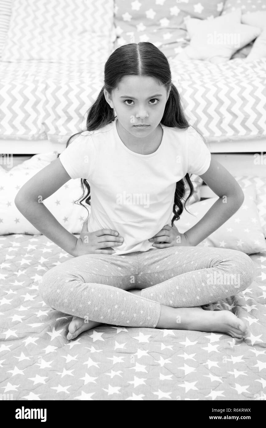 Do not disturb child before sleep. Girl child sit on bed in her bedroom