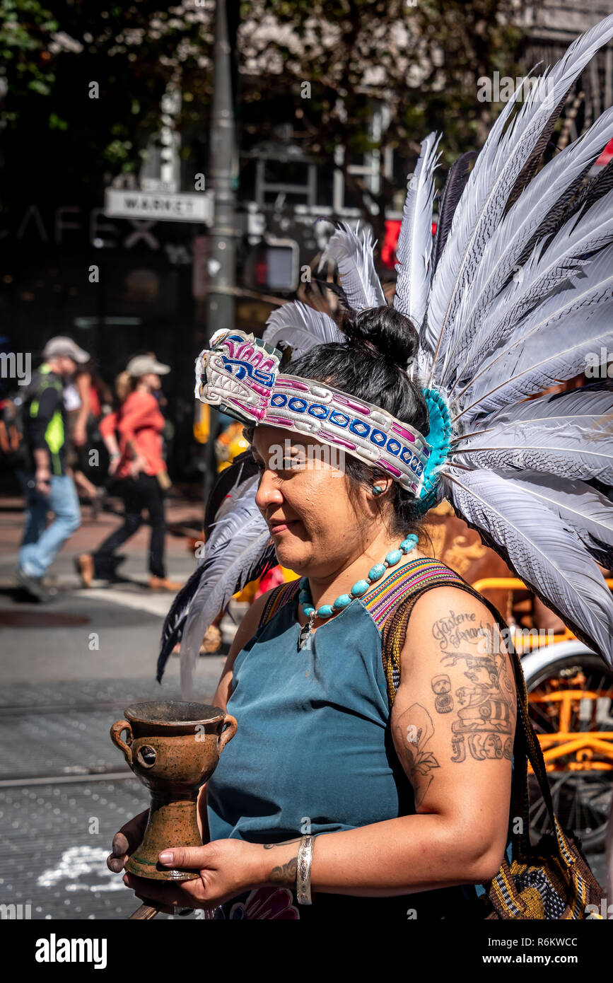 San Francisco, California, USA. 8th September, 2018. Thousands gather in San Francisco in Rise for Climate rally and march in advance of the Global Climate Action Summit to be held there September 12 to 14. A Native American woman wearing feathered regalia marches with a group down Market Street. Stock Photo