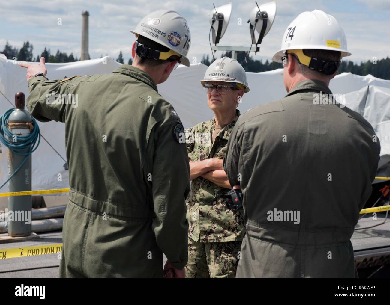 BREMERTON, Washington (May 19, 2017) Capt. Gregory Huffman, commanding officer of USS John C. Stennis (CVN 74) and Cmdr. Pavao Huldisch, John C. Stennis’ air boss, describe the ongoing maintenance of the flight deck to Vice Adm. Nora Tyson, commander, U.S. 3rd Fleet, during a tour of the ship. Tyson is visiting the Pacific Northwest to speak with Sailors during various all hands calls around Naval Base Kitsap and to serve as grand marshal of the 69th annual Bremerton Armed Forces Day Parade. John C. Stennis is conducting a planned incremental availability (PIA) at Puget Sound Naval Shipyard an Stock Photo
