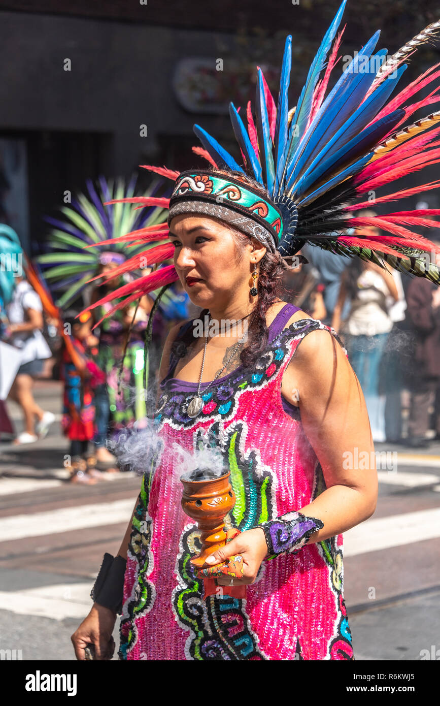 San Francisco, California, USA. 8th September, 2018. Thousands gather in San Francisco in Rise for Climate rally and march in advance of the Global Climate Action Summit to be held there September 12 to 14. A Native American woman wearing feathered regalia marches with a group down Market Street. Stock Photo