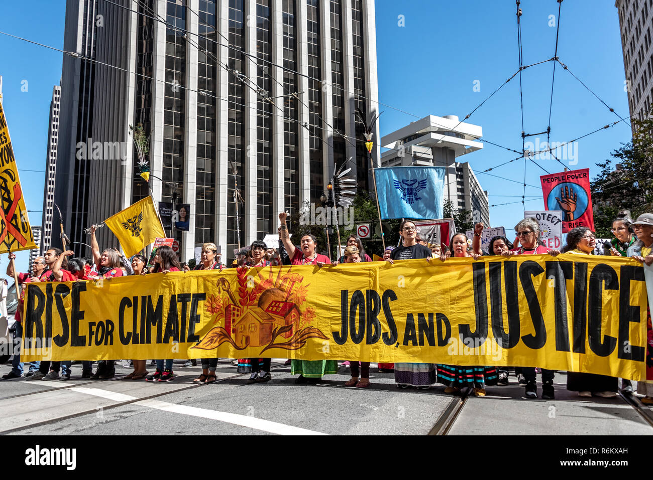 San Francisco, California, USA. 8th September, 2018. Thousands gather in San Francisco in Rise for Climate rally and march in advance of the Global Climate Action Summit to be held there September 12 to 14. A large group of Native American people from the Kutzadika tribe of Mono Lake Basin hold a wide yellow banner in reading 'Rise for climate, jobs and justice' as they march down Market Street. Stock Photo