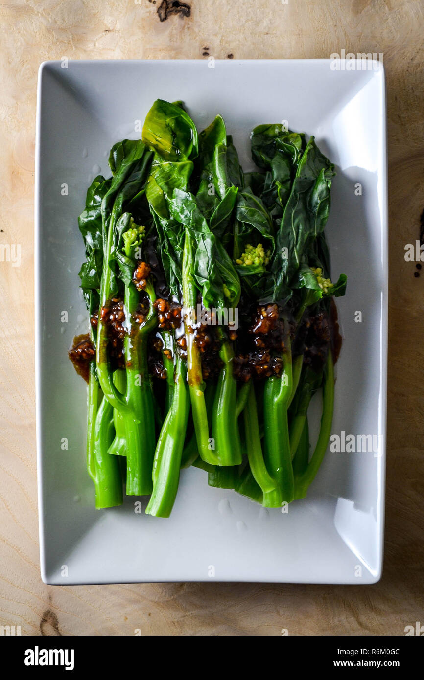 Blanched gai lan with garlic and oyster sauce (Chinese cooking) Stock Photo