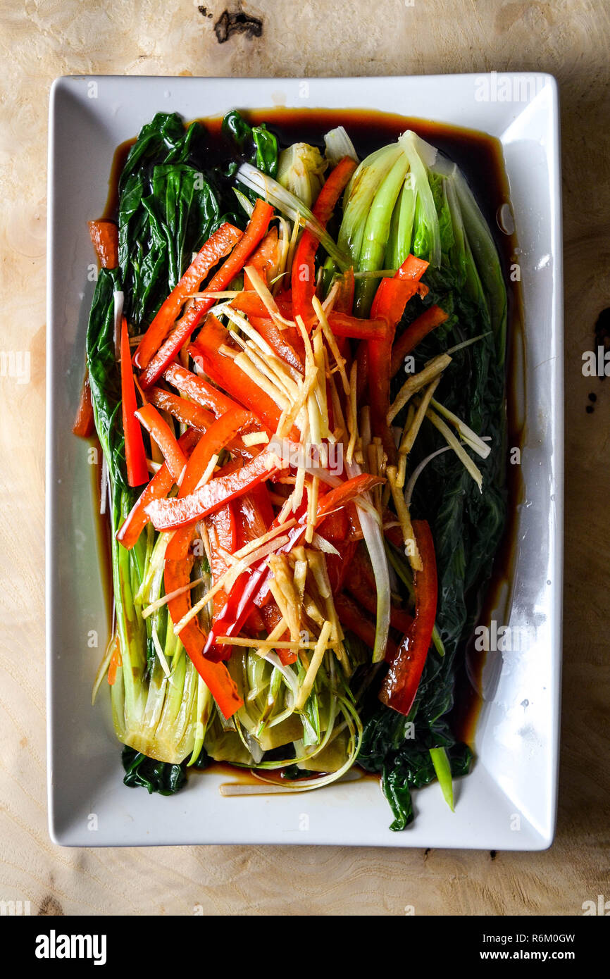 Blanched tatsoi (rosette bok choy) and peppers with sizzling oil (Chinese cooking) Stock Photo