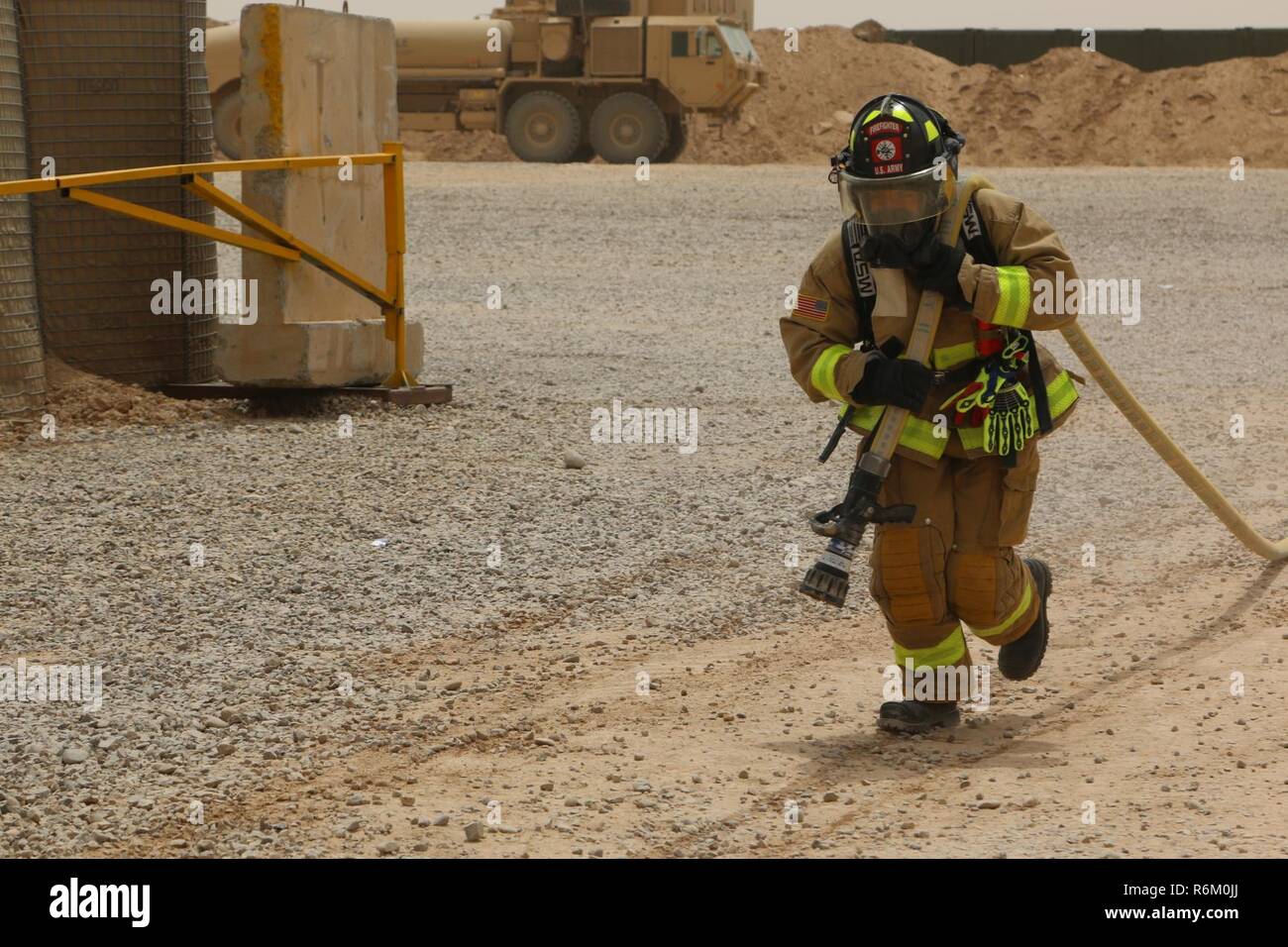 A U.S. Army Soldier, deployed in support of Combined Joint Task Force-Operation Inherent Resolve, competes in a firefighters’ physical training challenge at Qayyarah West Airfield, Iraq, May 19, 2017. The Soldier, assigned to the “Q-West” firefighters team consisting of members from the 562nd Firefighter Detachment and 514th Firefighter Detachment, helped create this challenge to bring different units on Qayyarah West Airfield together and promote physical fitness. CJTF-OIR is the global Coalition to defeat ISIS in Iraq and Syria. Stock Photo
