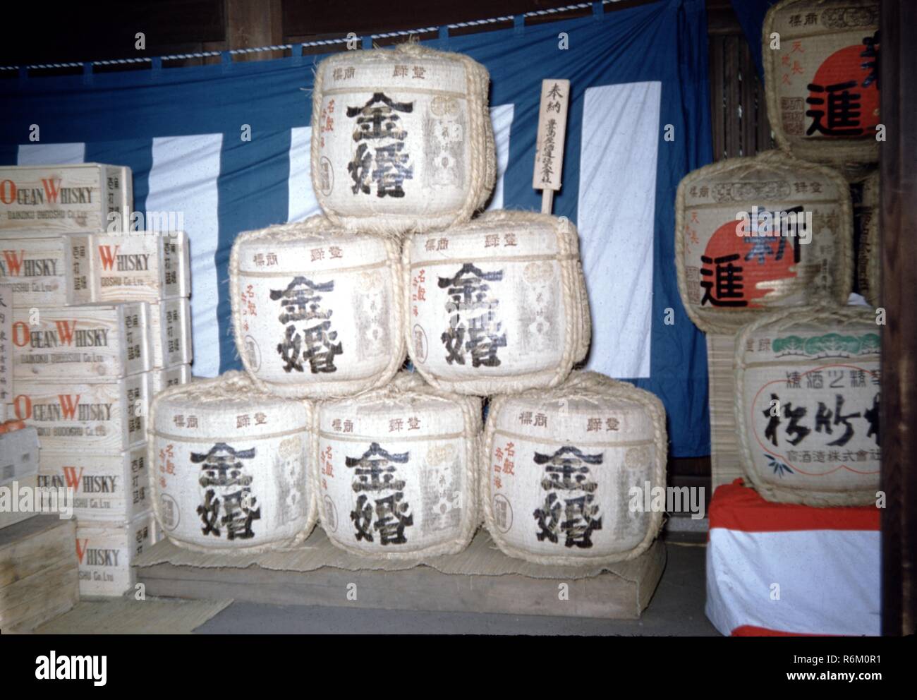 Download Color Photograph Of Liquor Containers Including Wooden Crates Marked Ocean Whiskey Left And Cylindrical Sake Or Japanese Rice Wine Containers With Japanese Text Center And Right Located In Japan 1965 Stock Photo Yellowimages Mockups