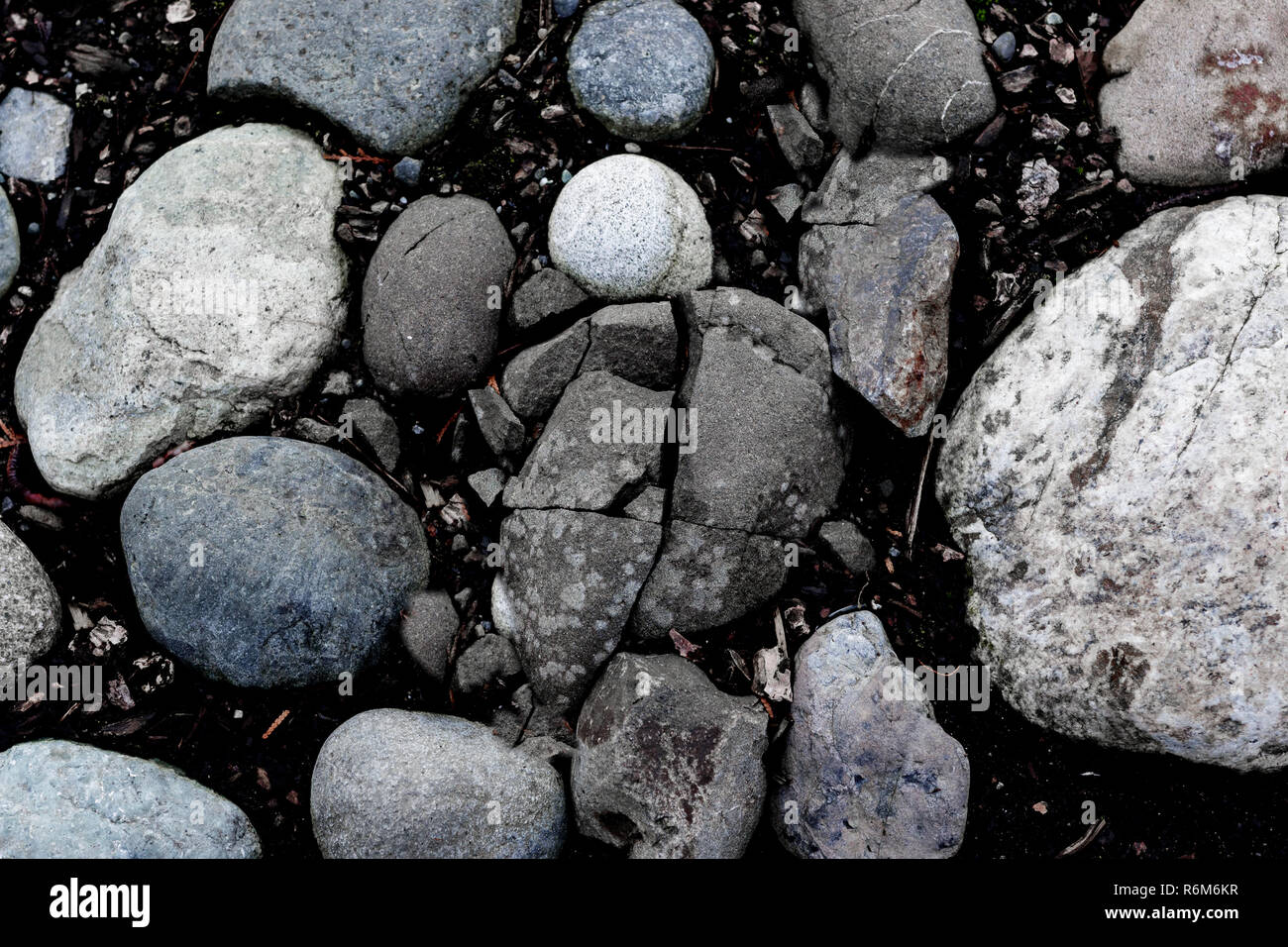 Round river rocks and a cracked stone background Stock Photo - Alamy