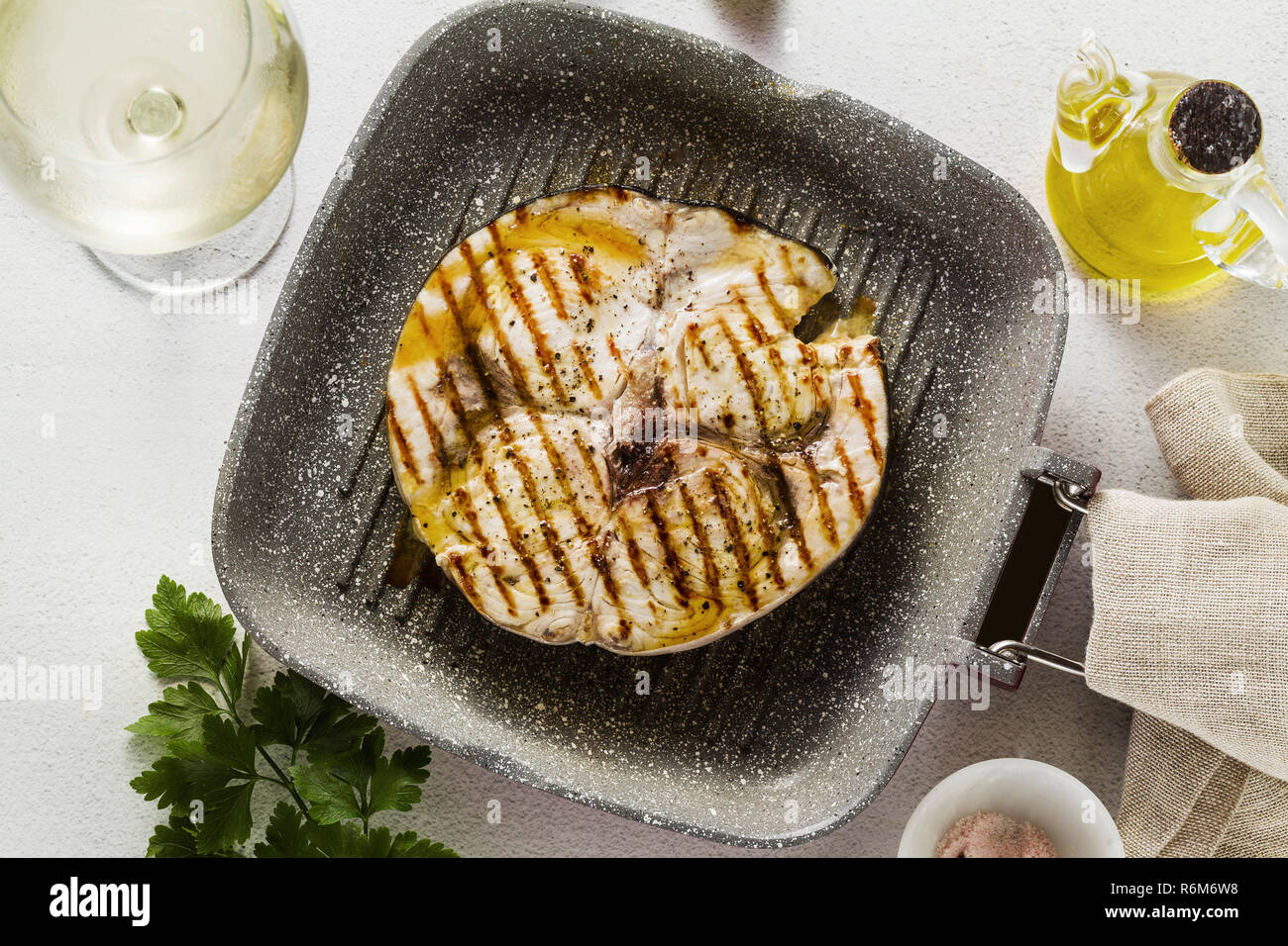 swordfish steak fried on grill pan with olive oil and spices. white