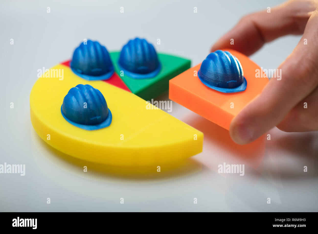 Human Hand Placing Last Orange Piece Into Pie Chart Stock Photo