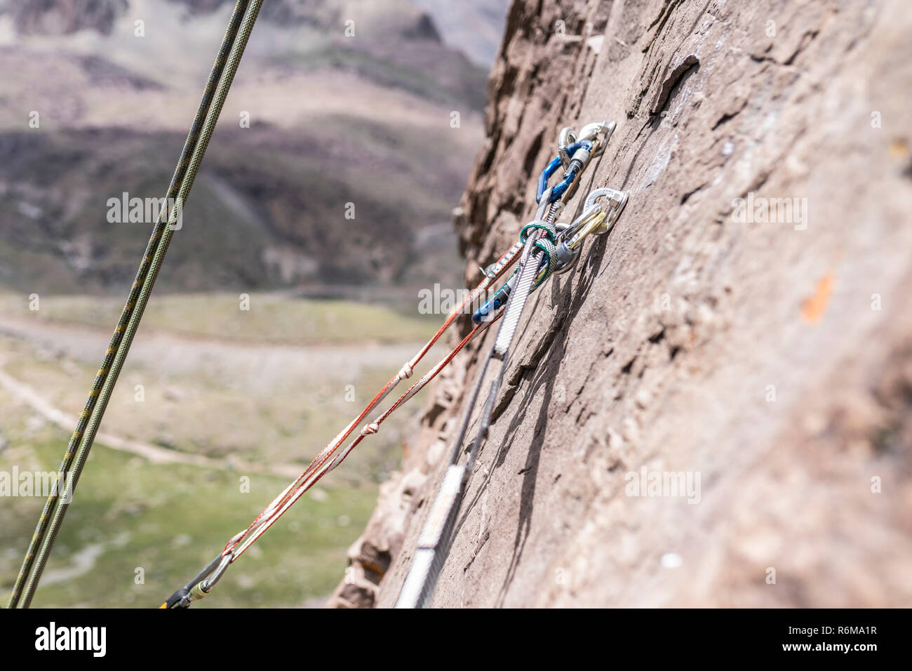 Rock climbing belay station in the middle of an Andes mountain rock