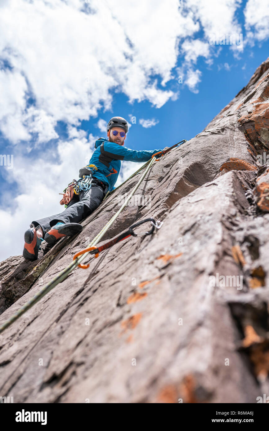 The last movements to reach the summit by a male climber. Rock climbing inside Andes mountains and valleys at Cajon del Maipo, an amazing place Stock Photo