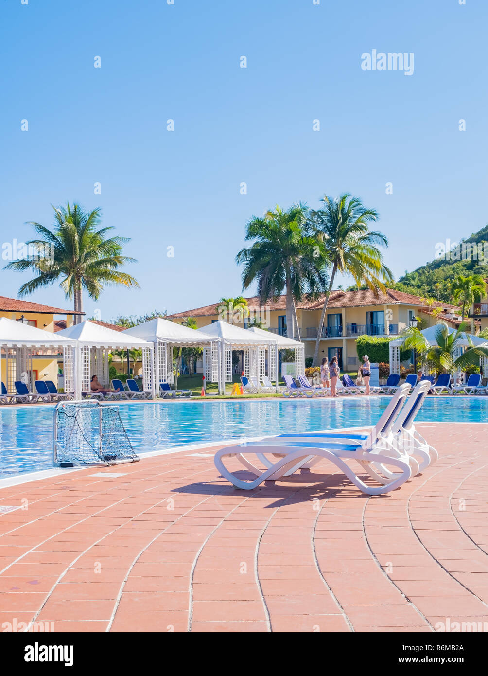 Two blue lounge chars beside a pristine beautiful swimming pool at a resort in Cuba, Stock Photo