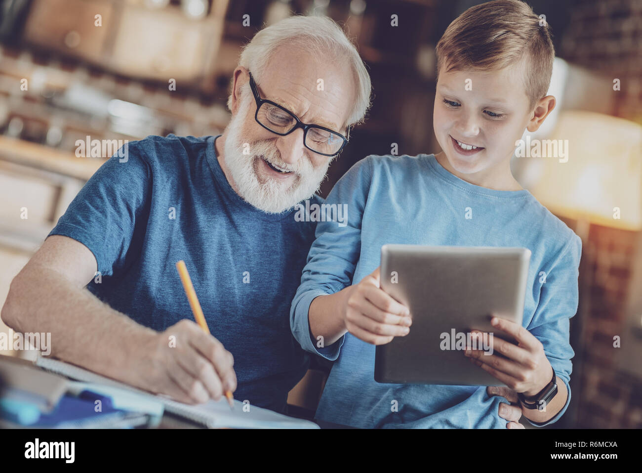 Cheerful grandfather helping his grandson Stock Photo