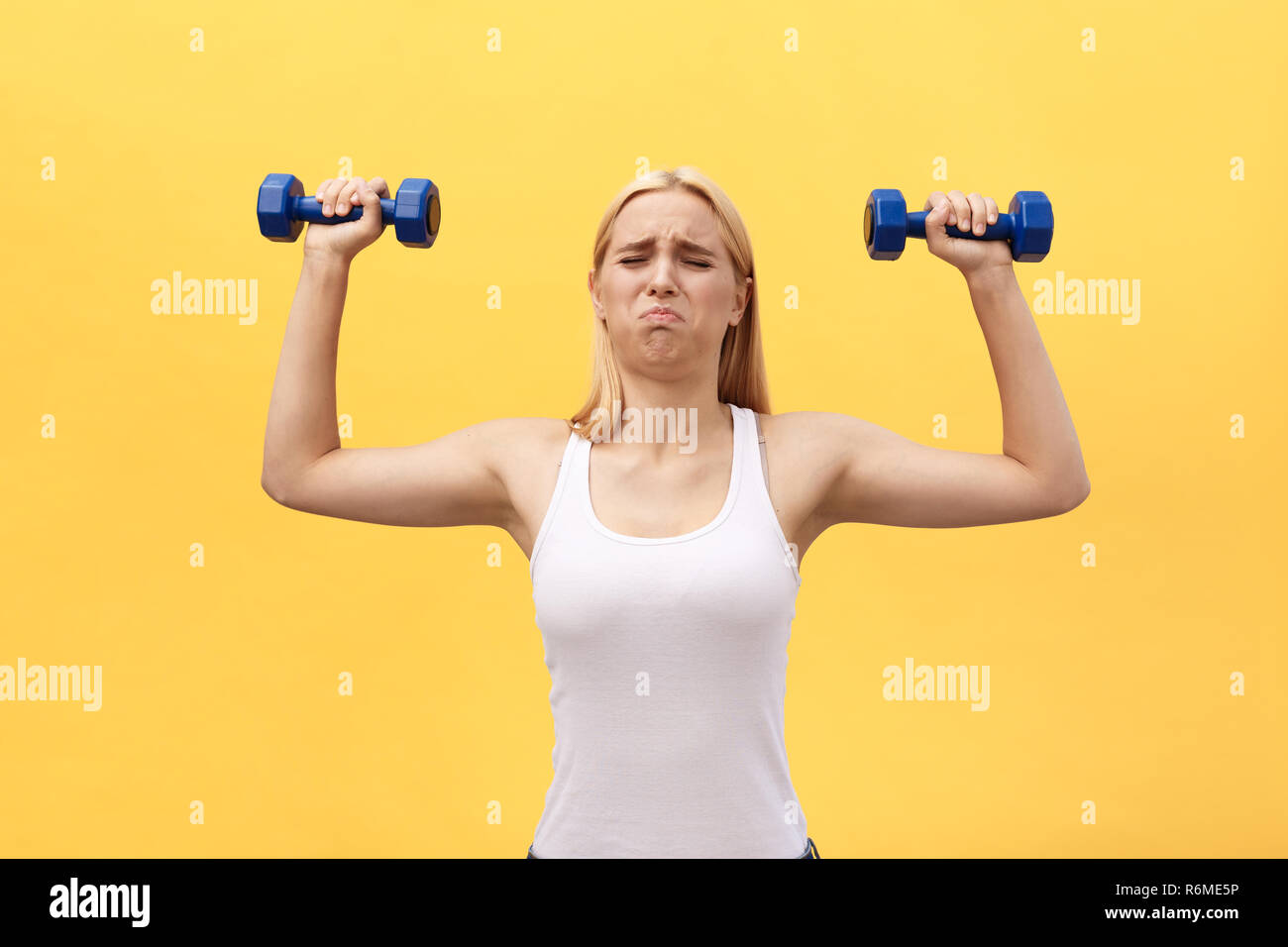 Strong young woman doing shoulder press with dumbell Stock Photo - Alamy