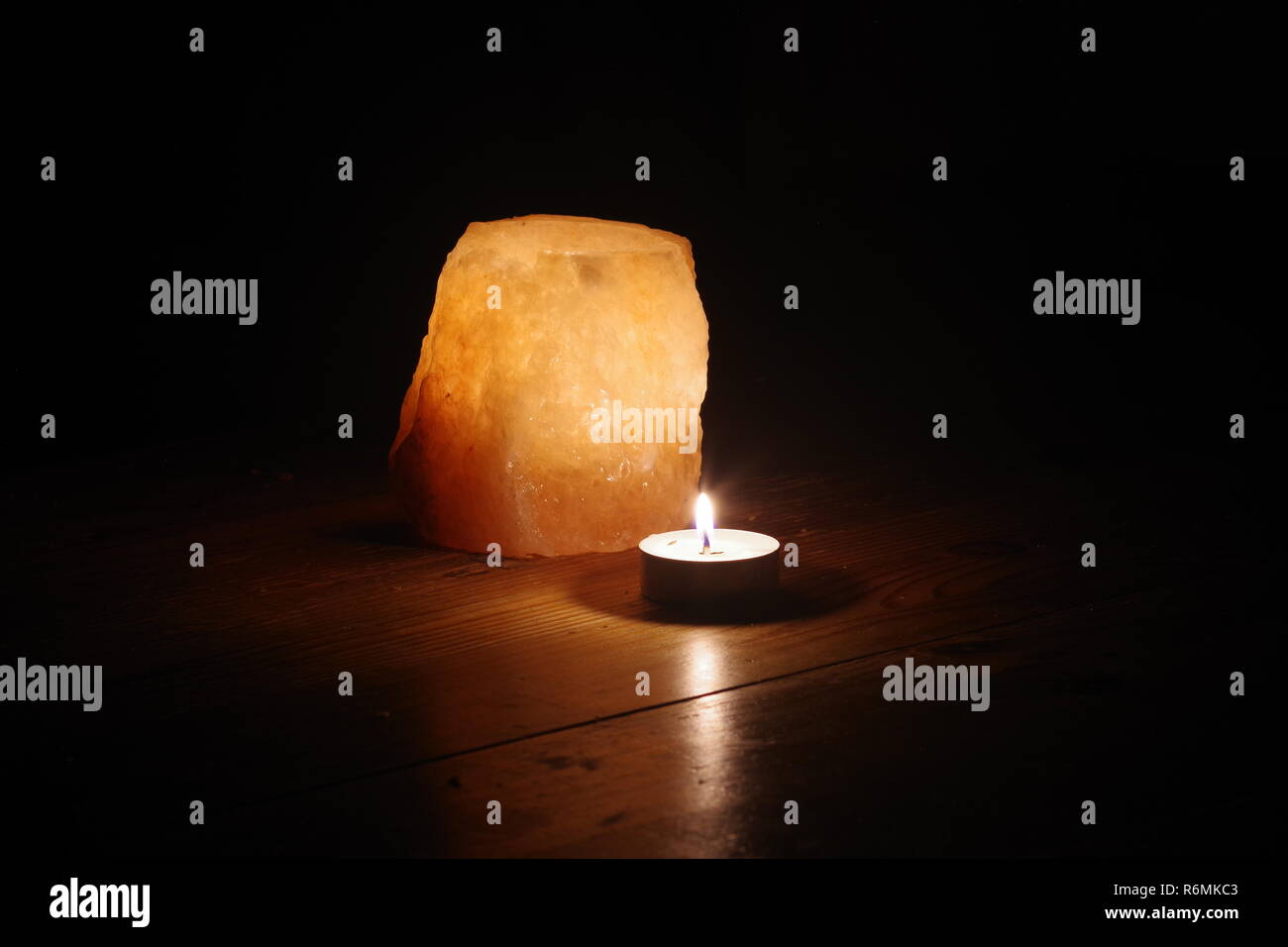 Tea light Candle by a Glowing Pink Rock Salt Candle Holder. Cosy Still
