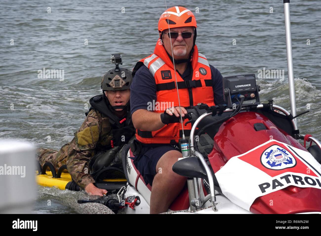 Master Sgt. James Henderson, 181st Weather Flight special operations weatherman, rides with a U.S. Coast Guard Auxiliary member to drop off his parachute gear after a deliberate water drop into Lake Worth in Fort Worth, Texas, May 20, 2017. The mission allowed 12 service members to parachute out of a C-130 Hercules from an altitude of 1000 feet into Lake Worth using MC-6 parachutes. (Texas Air National Guard Stock Photo