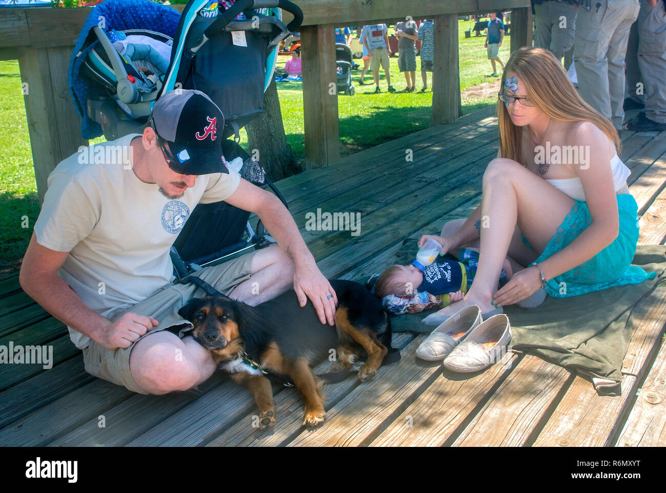 A young couple relaxes with their baby and puppy while waiting for the 66th annual Blessing of the Fleet in Bayou La Batre, Alabama, May 3, 2015. Stock Photo