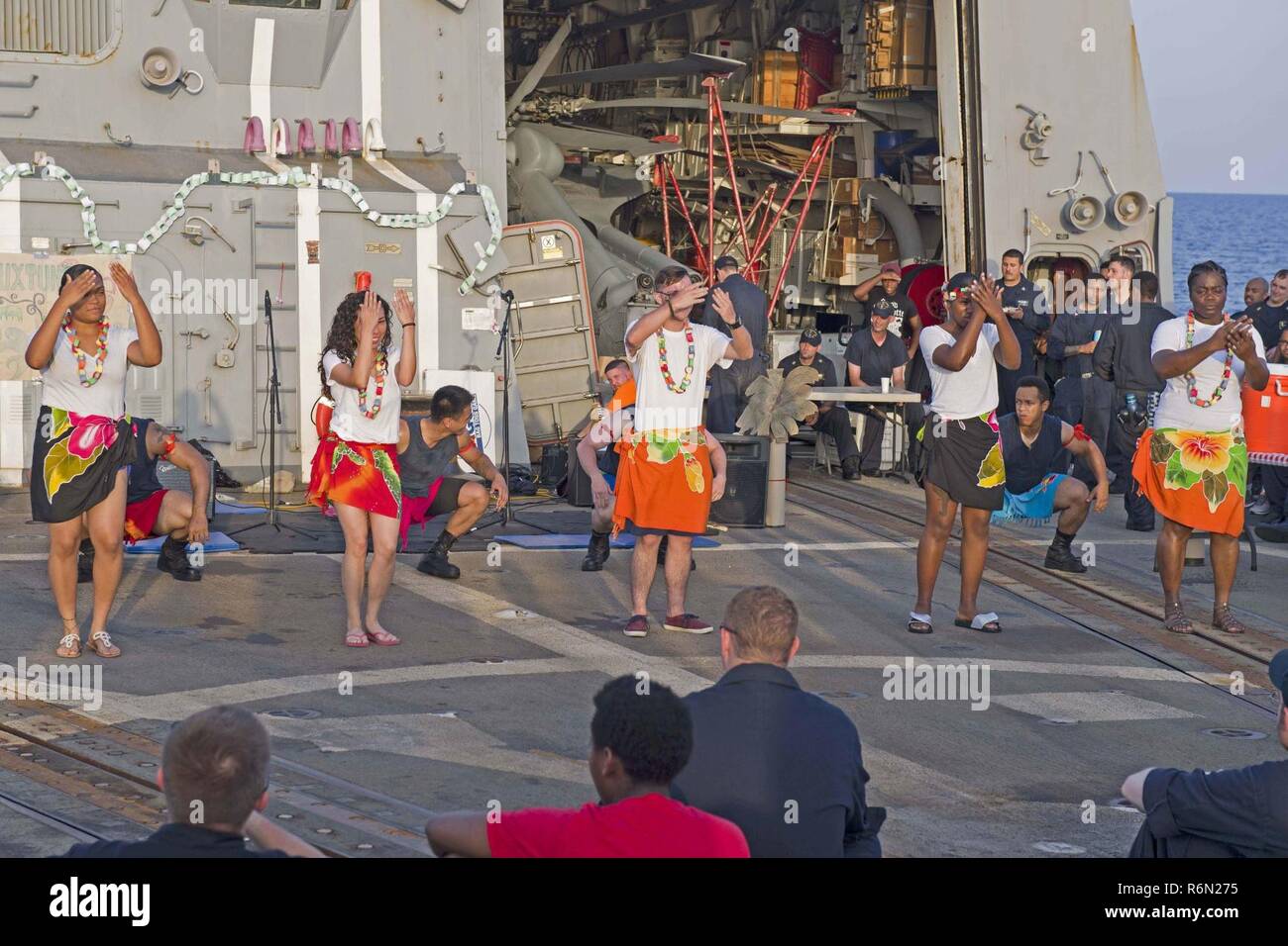 U.S. 5TH FLEET AREA OF OPERATIONS (May 27, 2017) Sailors perform a Samoan dance during a luau to celebrate Asian-American and Pacific Islander Heritage Month (AAPIHM) on the flight deck of the guided-missile destroyer USS Truxtun (DDG 103). Truxtun is part of the George H.W. Bush Carrier Strike Group deployed in the U.S. 5th Fleet area of operations in support of maritime security operations designed to reassure allies and partners, preserve the freedom of navigation and the free flow of commerce in the region. Stock Photo