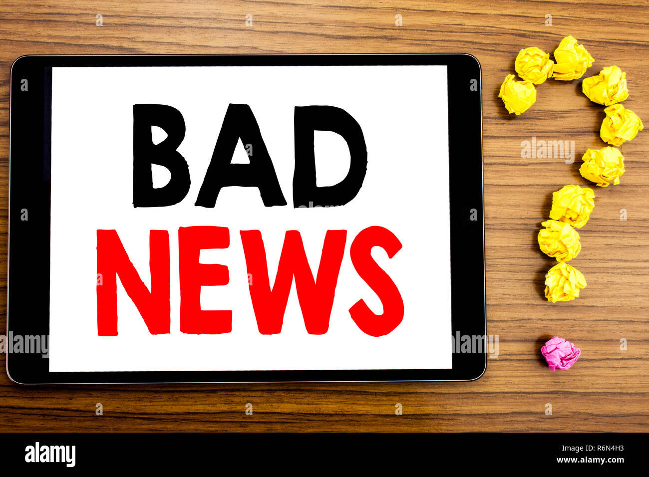 Writing text showing Bad News. Business concept for Failure Media Newspaper written on tablet computer on the wooden background with question mark made of folded paper. Stock Photo
