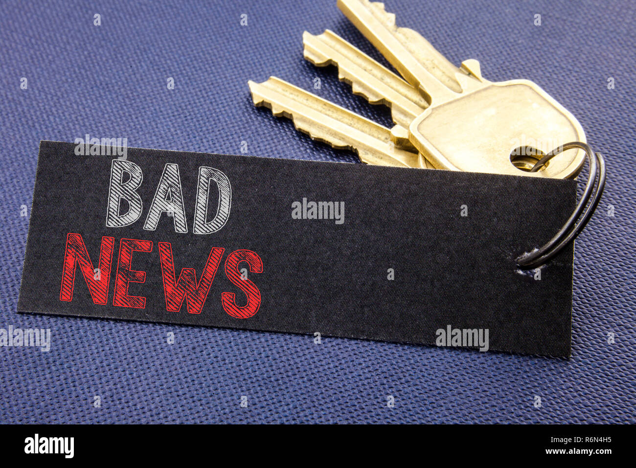 Handwritten text showing Bad News. Business concept writing for Failure Media Newspaper Written on note paper attached to the key, black background with space close up Stock Photo
