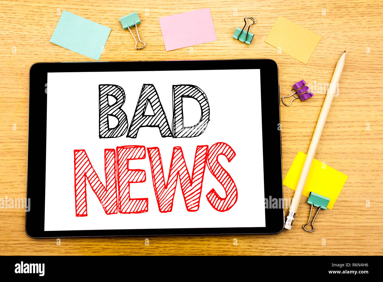 Writing text showing Bad News. Business concept for Failure Media Newspaper Written on tablet laptop, wooden background with sticky note and pen Stock Photo