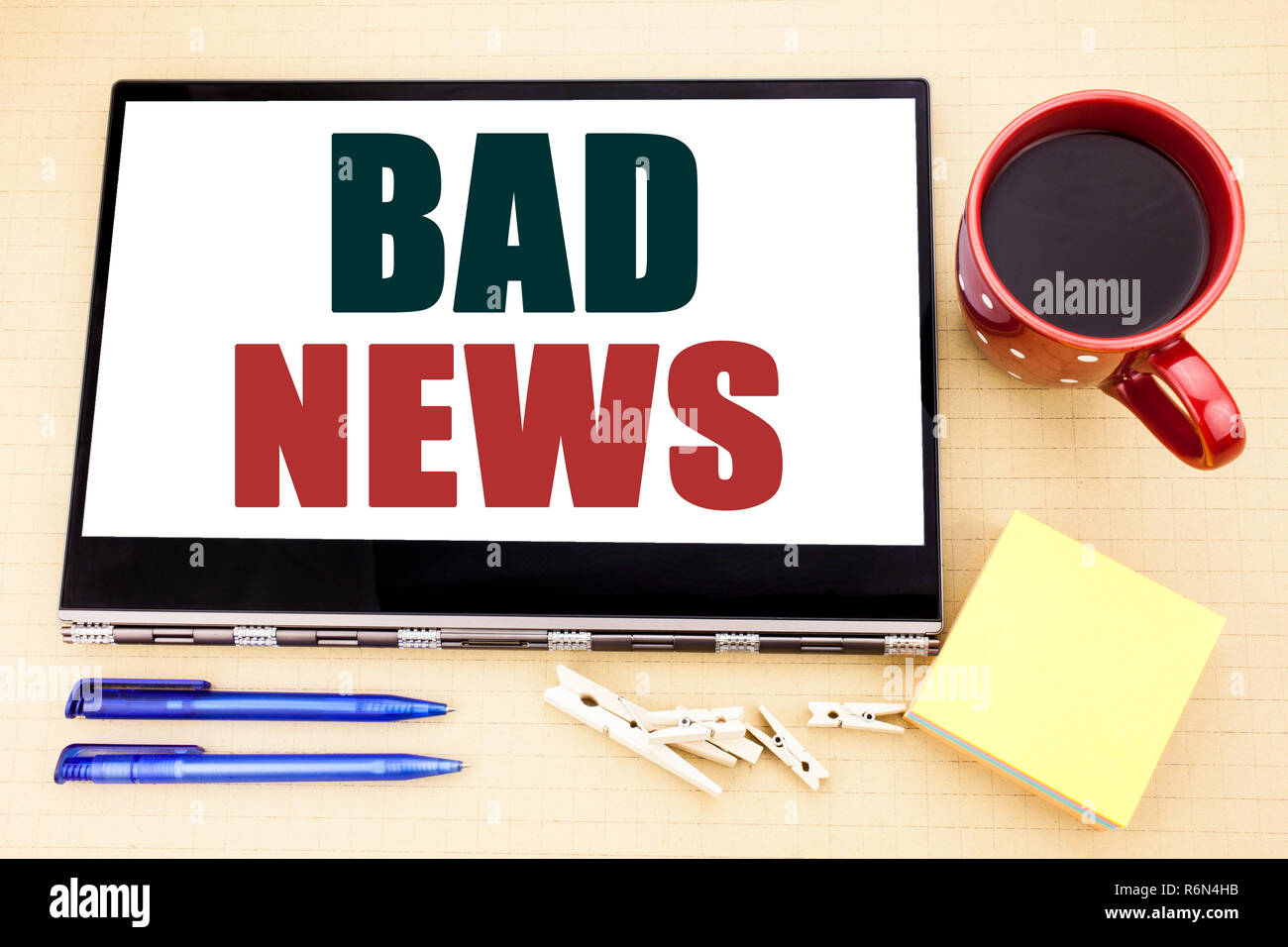 Hand writing text caption inspiration showing Bad News. Business concept for Failure Media Newspaper written on tablet laptop. Office place with coffee cup, pen and sticky note. Stock Photo