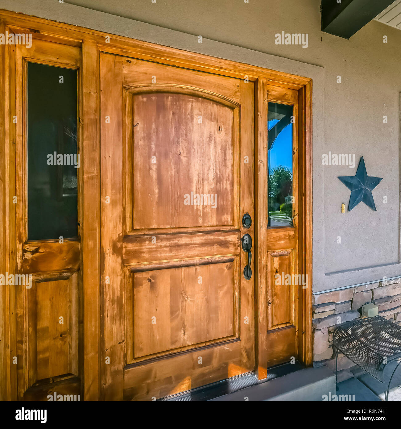 Brown Wood Front Door With Reflective Glass Panels Stock