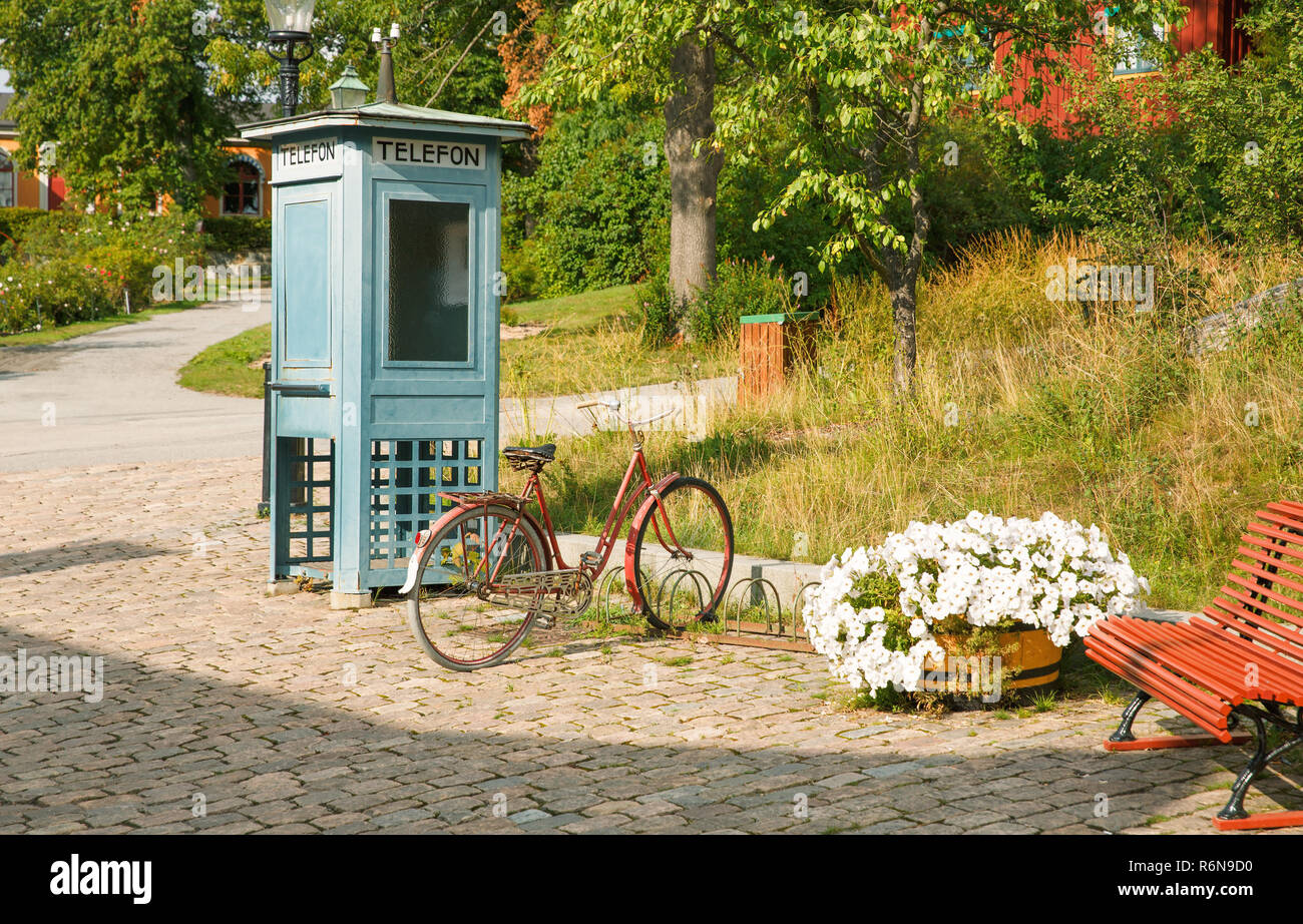 Old phone box and bicycle at Skansen, the first open-air museum and zoo, located on the island Djurgarden in Stockholm, Sweden. Stock Photo