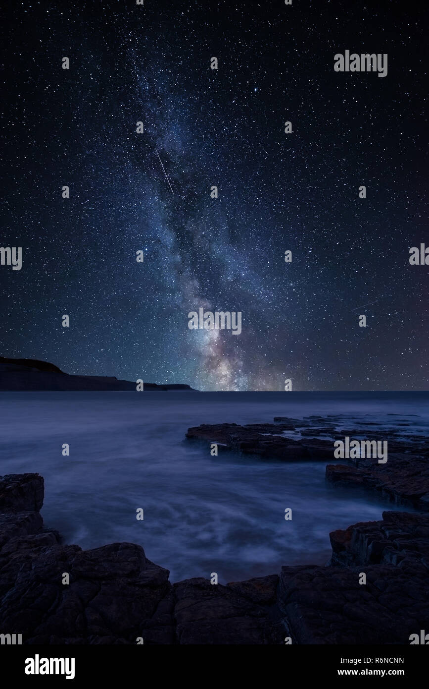 Stunning vibrant Milky Way composite image over landscape of coastline ...