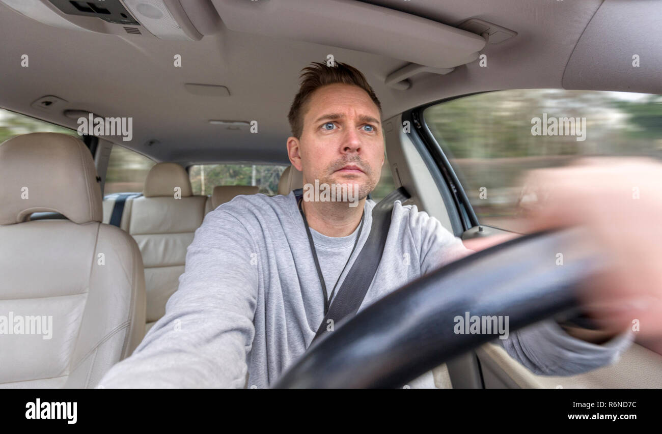 FLODA, SWEDEN - DECEMBER 4 2018: Mid adult caucasian man looking concentrated or worried when driving car Stock Photo