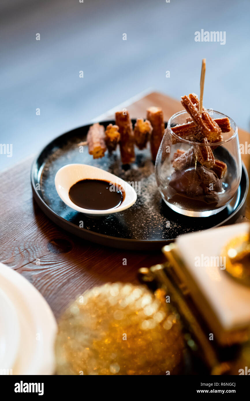 Elegant Churros with Sugar and Chocolate Sauce on Fancy Display in Glass and Plate Gastronomy Close Stock Photo