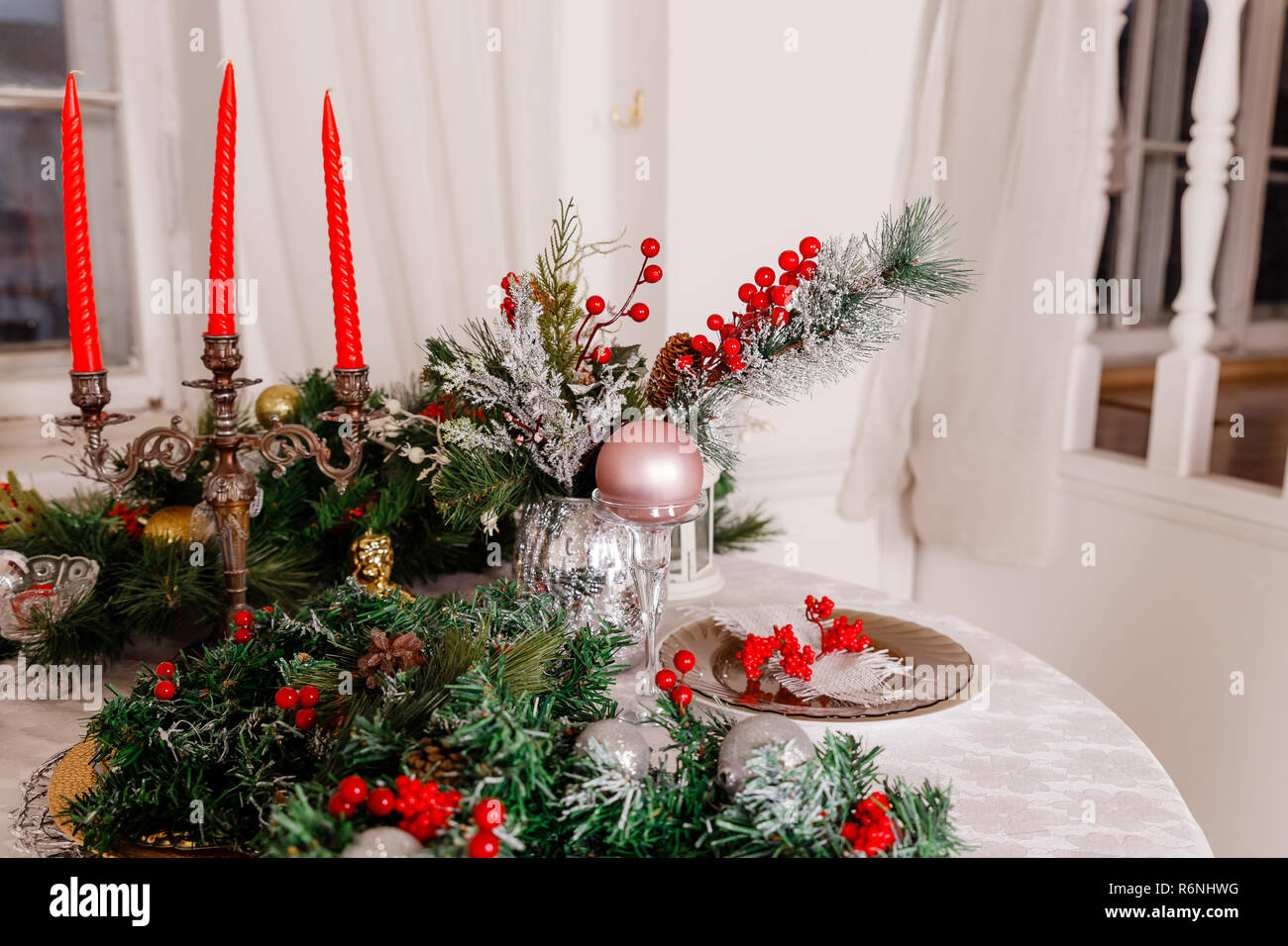 Christmas Family Dinner Table Concept Table Setting For New Year Dinner Decorations Candles And Lanterns White Tablecloth Living Room Decorated With Lights And Christmas Tree Holiday Setting Christmas Red Candles Stock Photo Alamy