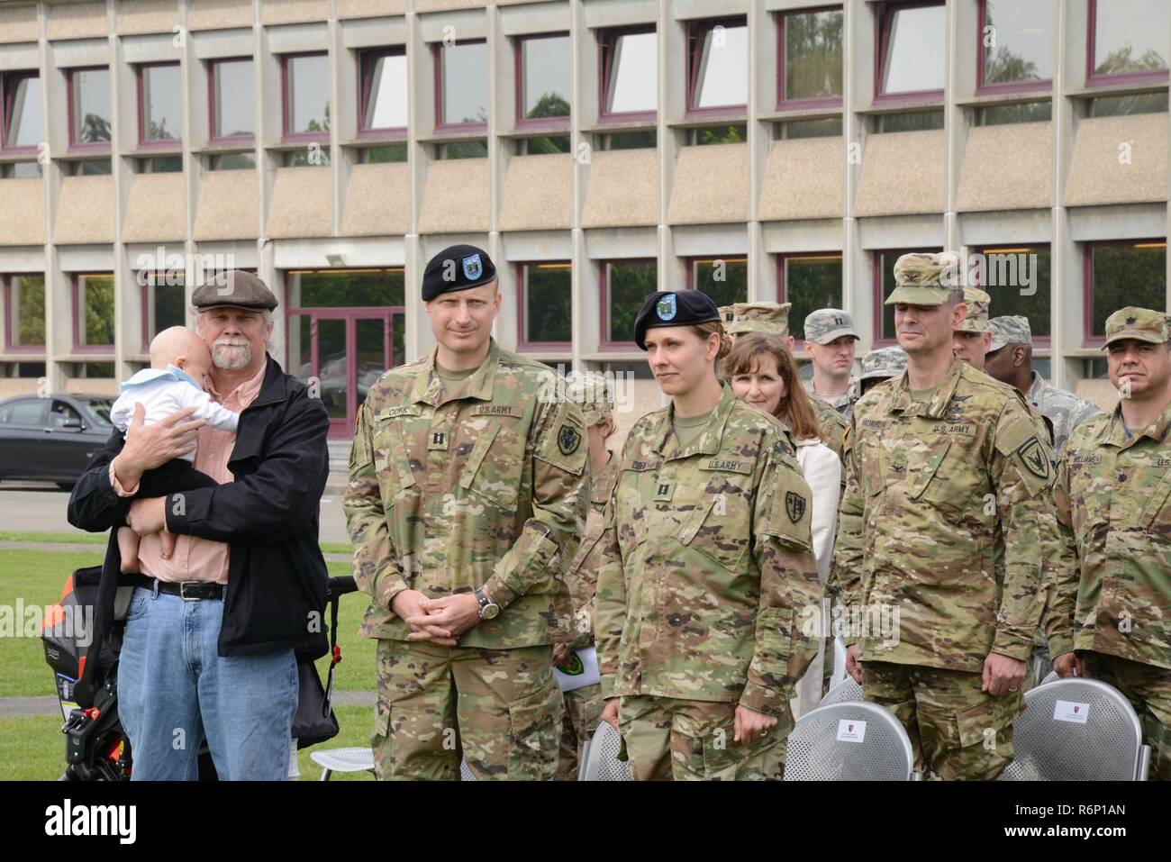 U.S. Army Cpt. Danielle K. Cork (outgoing Commander) with her husband, father, and son, stand