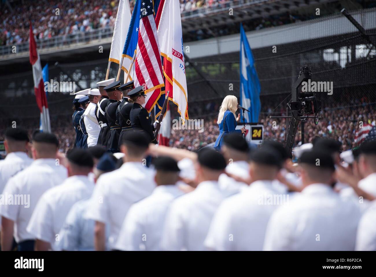 Service members from across the armed forces salute the colors while Bebe Rexha sings the National Anthem during the pre-race events at the Indy 500 on May 28, 2017. Stock Photo