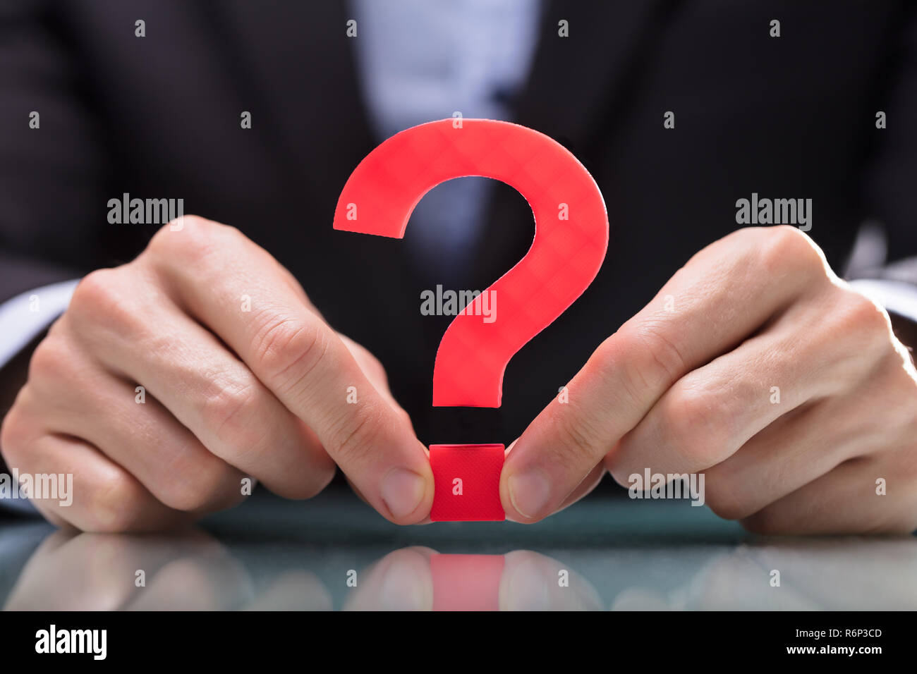 Businessperson Holding Question Mark Sign Stock Photo