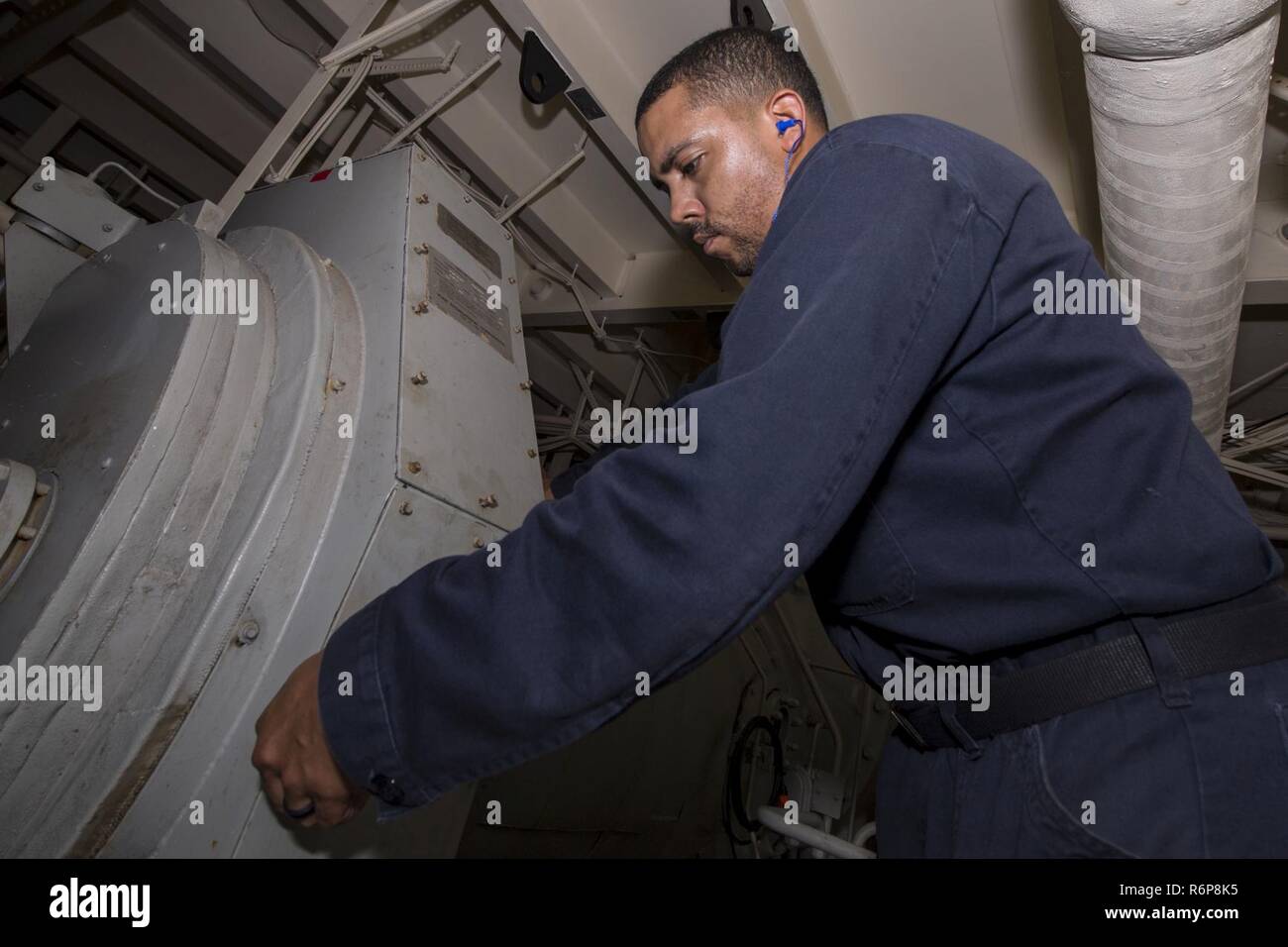 SOUTH CHINA SEA (Aug. 19, 2017) Electrician’s Mate 2nd Class Alpha Dowlen, a native of Clarksville, Tennessee, assigned to the amphibious assault ship USS America (LHA 6) Engineering department, conducts a quality assurance check on a de-energized air conditioning unit in the ship’s auxillary room. America, part of the America Amphibious Ready Group, with embarked 15th Marine Expeditionary Unit, is operating in the Indo-Asia Pacific region to strengthen partnerships and serve as a ready-response force for any type of contingency. Stock Photo