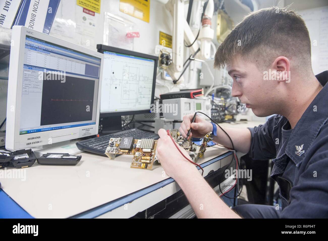 INDIAN OCEAN (Sept. 22, 2017) Electronics Technician 2nd Class Jeremy  Slager, assigned to the amphibious dock landing ship USS Pearl Harbor (LSD  52), troubleshoots a direct current convertor for a very-high frequency