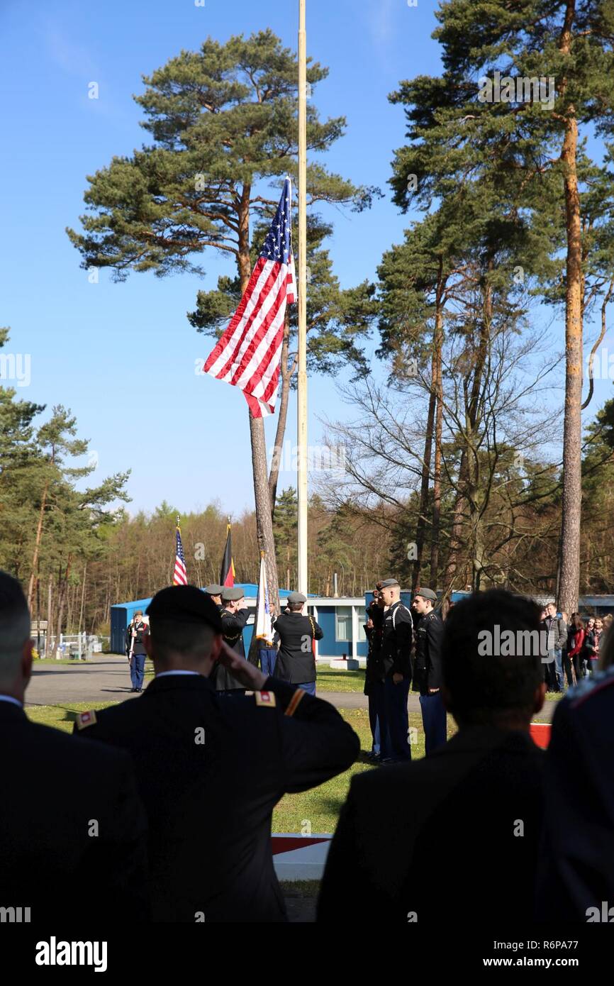 U.S. Army Lt. Col. Chris Keeshan, 2nd Signal Brigade deputy brigade commander, salutes as the American flag is raised during a ceremony marking 27 years since the last patrol along the former border between East Germany and West Germany at the Point Alpha camp, April 28, 2017 near Rasdorf, Germany. Stock Photo