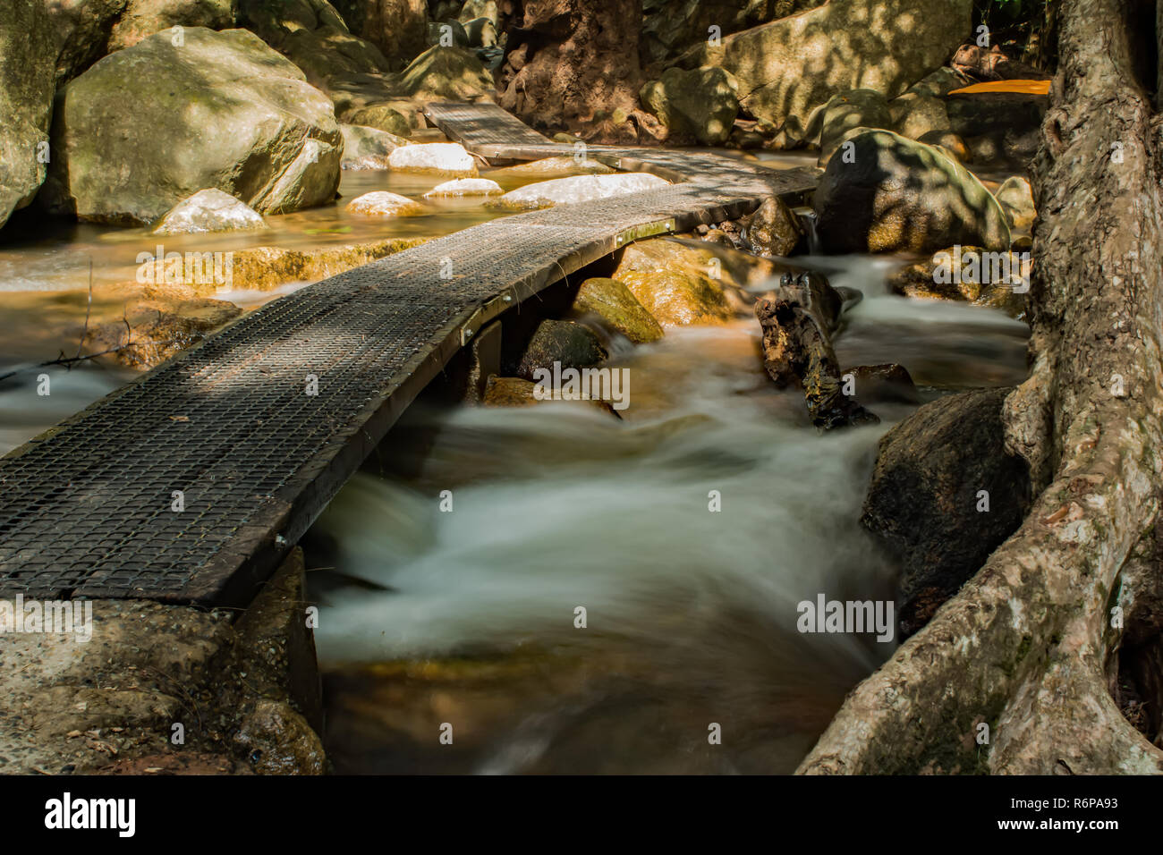 Walkway across a creek flowing through rocks at Jourama Falls, Ingham, Qld AU Stock Photo