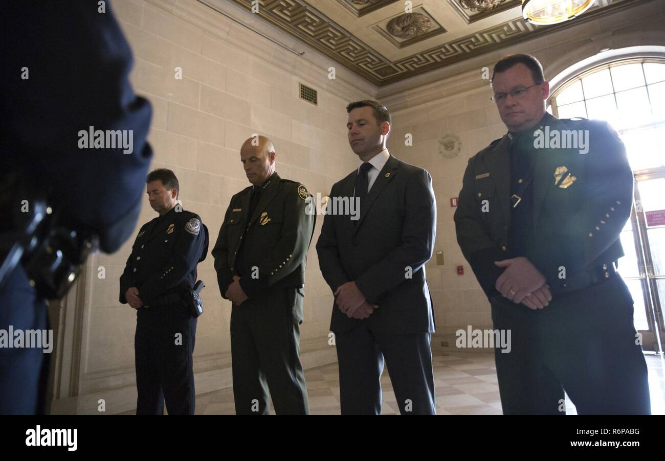 Historical photograph of CBP Commissioner Kevin K. McAleenan: U.S. Customs and Border Protection Acting Commissioner Kevin K. McAleenan, second from right, and U.S. Customs and Border Protection Acting Deputy Commissioner Ronald D. Vitiello, second from left, pause for a moment of silence after placing a wreath in memory of fallen Immigration and Naturalization Service inspectors at a memorial housed in the Environmental Protection Agency Building in Washington, D.C., May 12, 2017. U.S. Customs and Border Protection Stock Photo