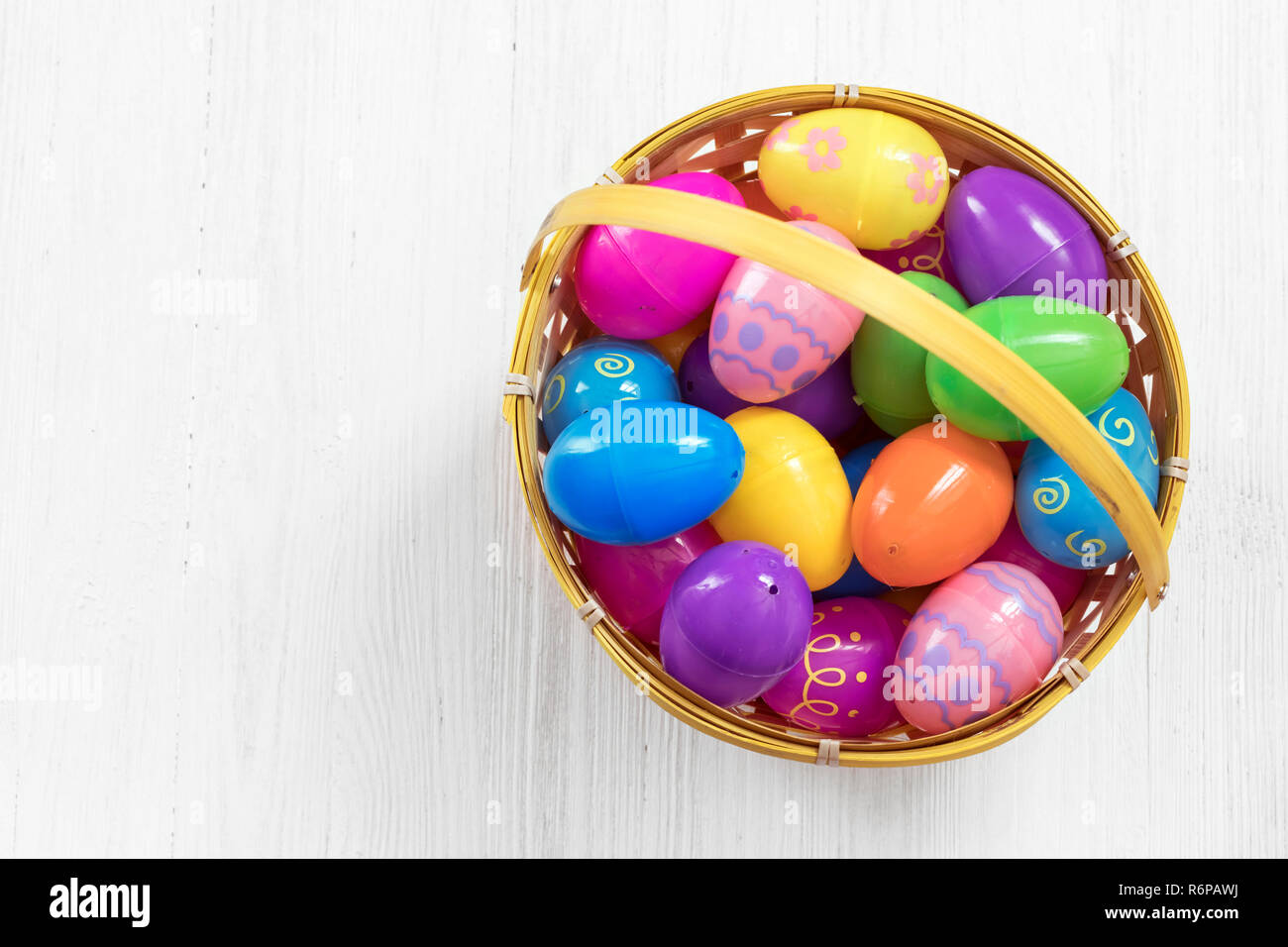 Easter eggs in basket on white wooden background Stock Photo - Alamy