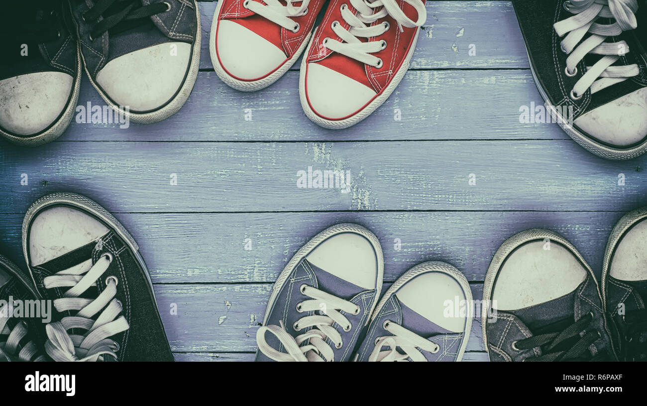 Six pairs of old, worn sneakers on a lilac wooden surface Stock Photo ...