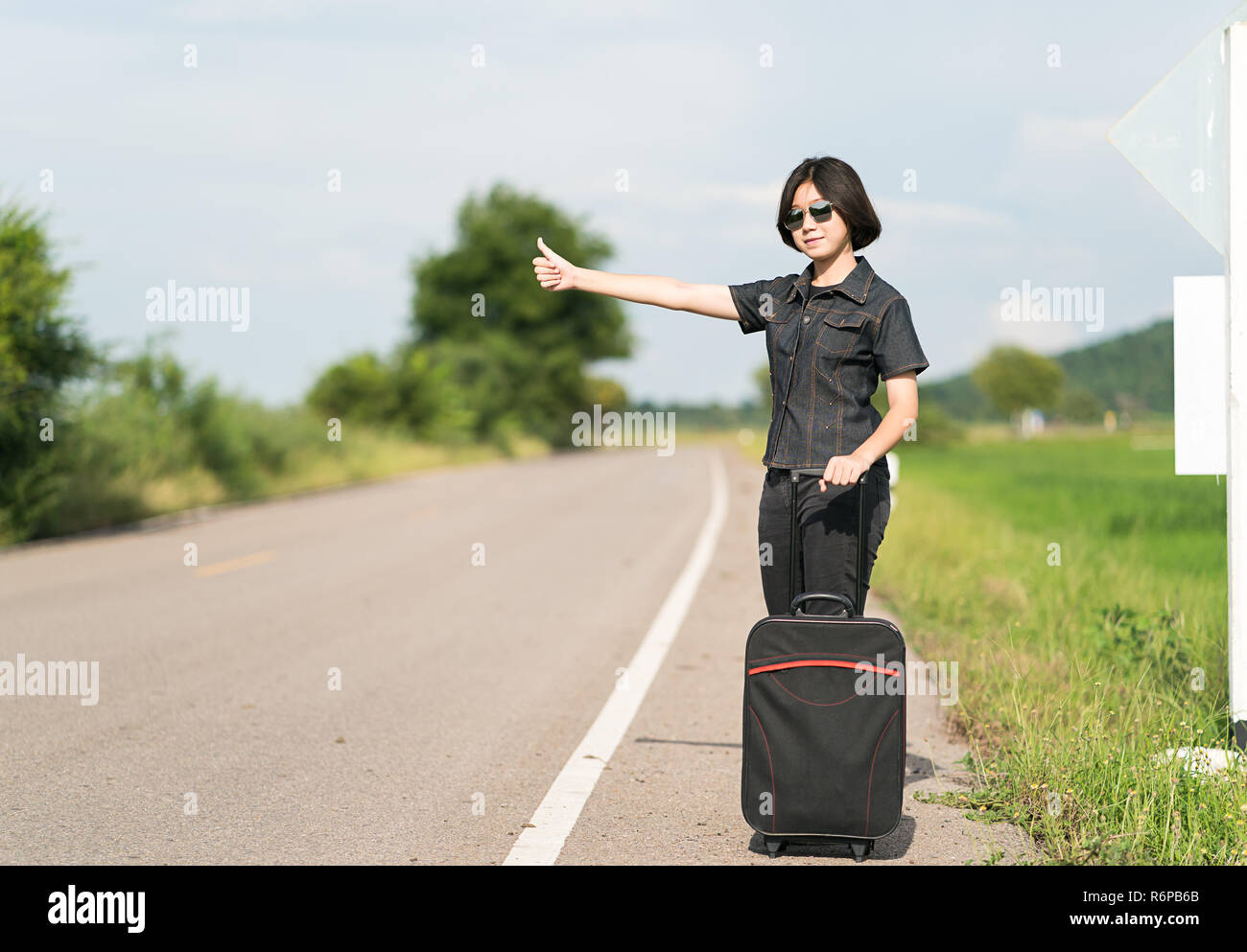 Woman Short Hair With Luggage Hitchhiking And Thumbs Up Stock