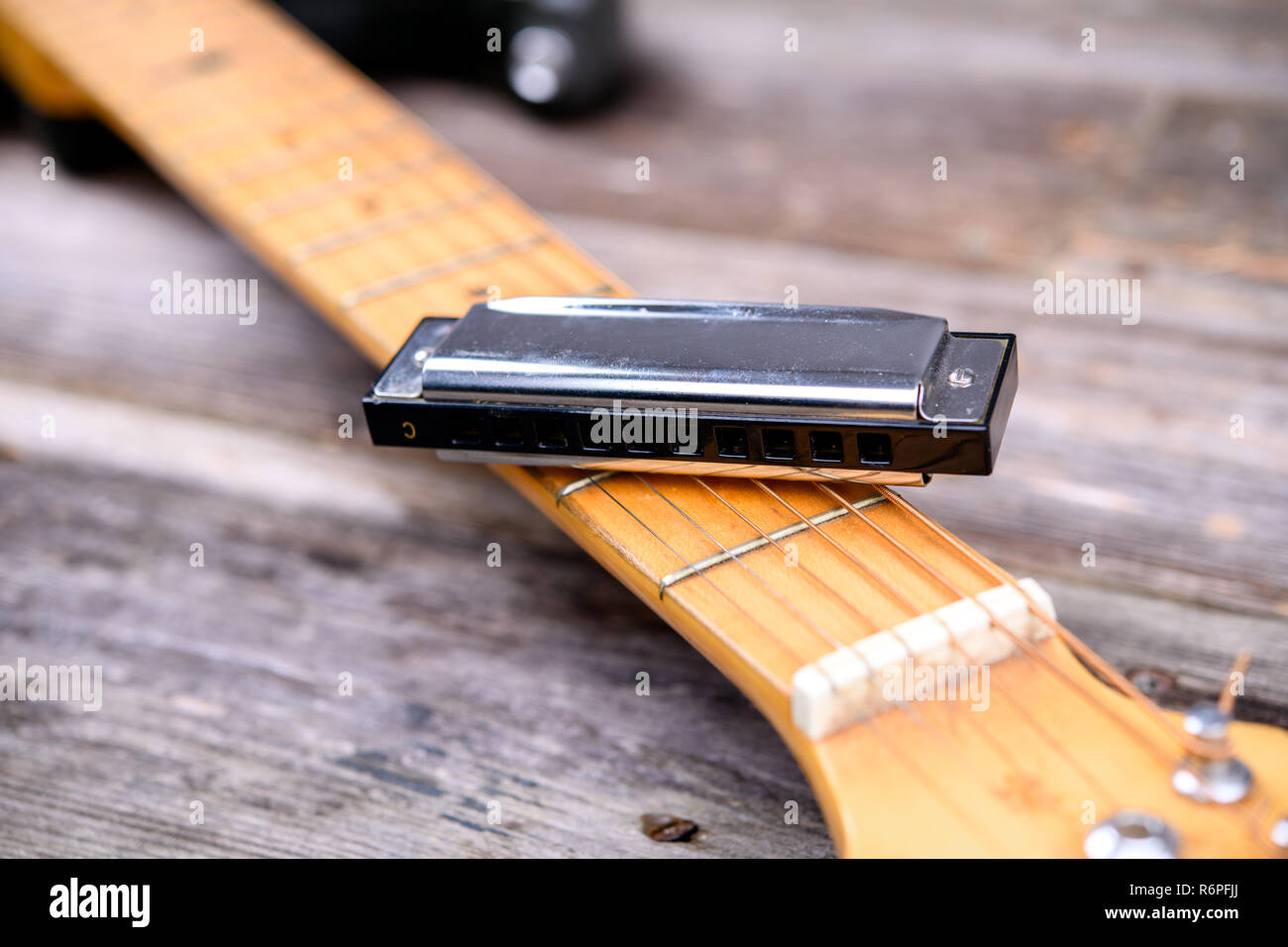 guitar with blues harmonica on wooden ground Stock Photo - Alamy